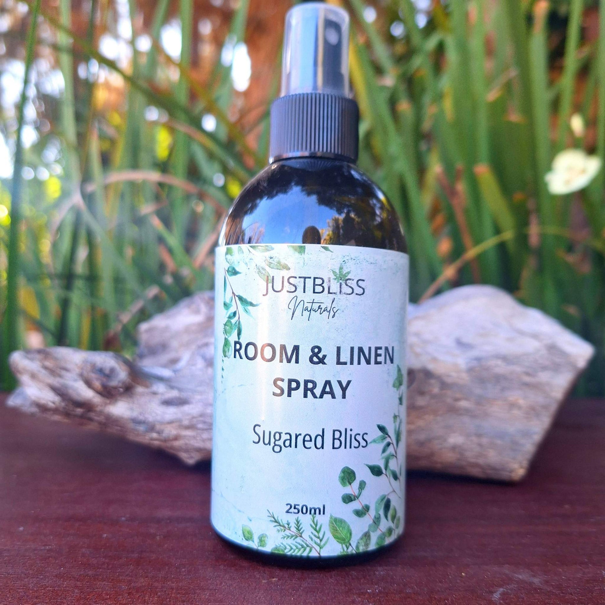 ROOM & LINEN SPRAY bottle of Sugared Bliss fragrance against a natural background.