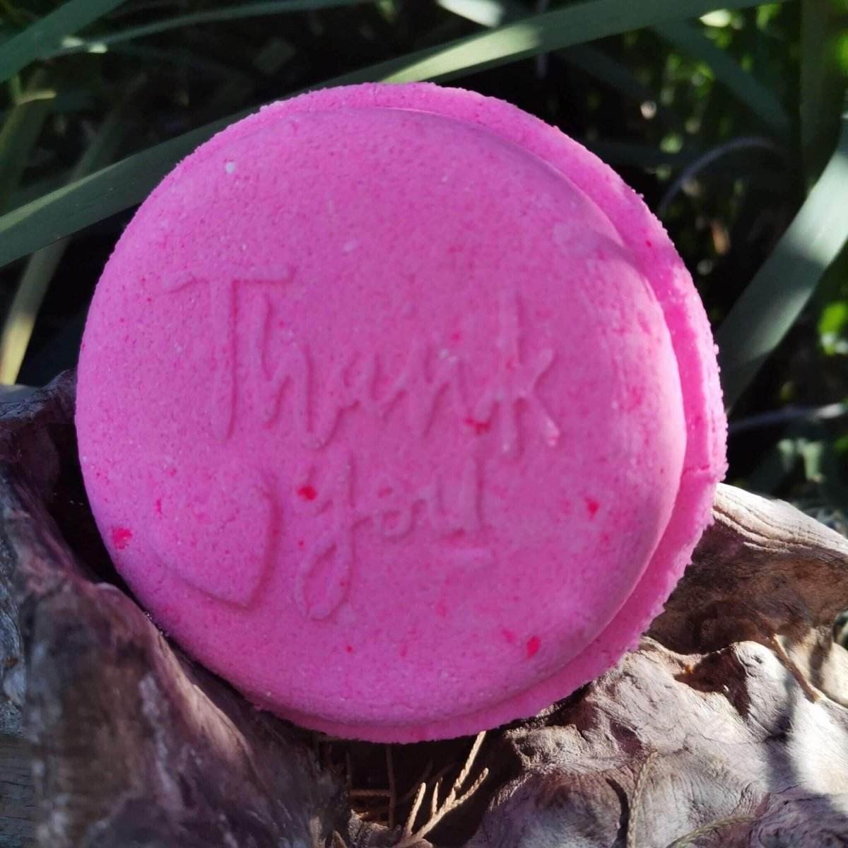 Pink "Thank You" bath bomb on a natural background.