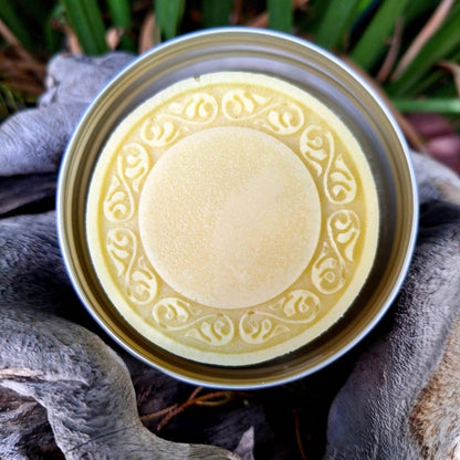 Pure Shower Lotion Bar in tin with intricate design, enriching skin with cocoa and shea butter for deep hydration.