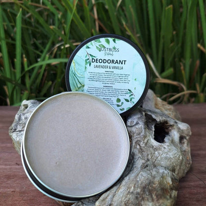 JUSTBLiSS Lavender & Vanilla natural deodorant cream in tin, displayed on rustic wood with green foliage background.