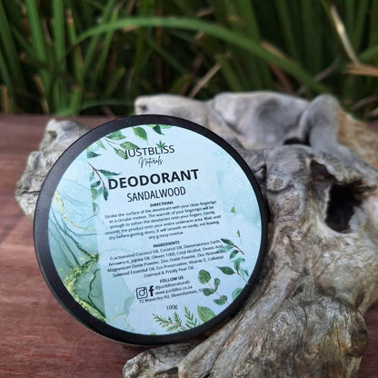 JUSTBLiSS Sandalwood natural deodorant tin on a wooden surface outdoors.