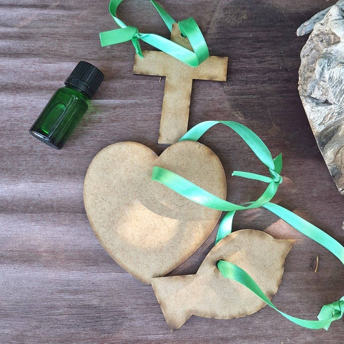 Wooden Hanging Diffuser with wooden shapes and fragrance oil bottle on a wooden surface.