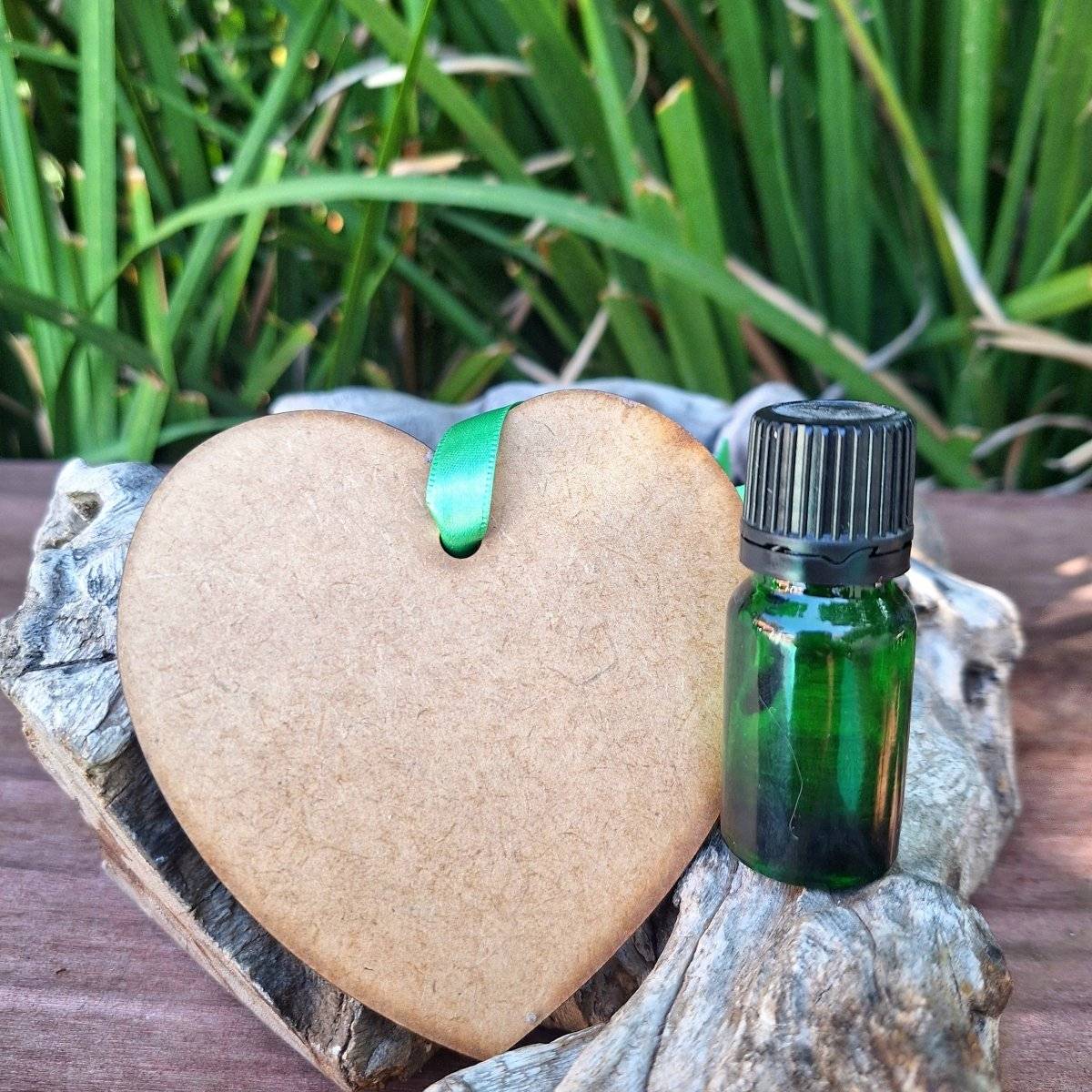 Wooden Hanging Diffuser with green essential oil bottle on wood background.