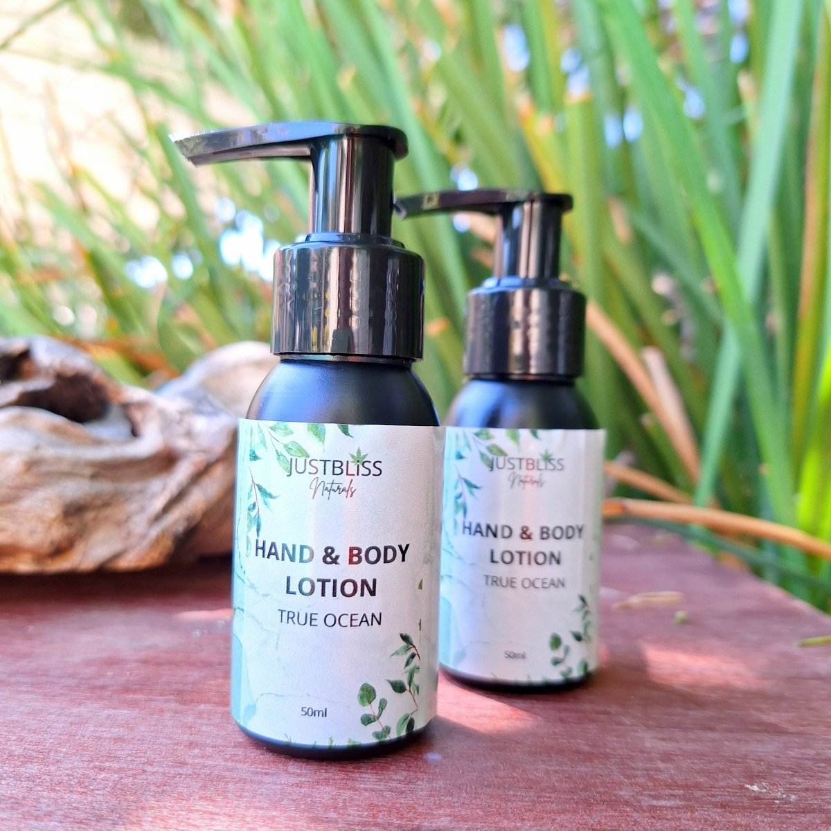 Travel size HAND & BODY LOTION 50ml bottle with natural oils background.