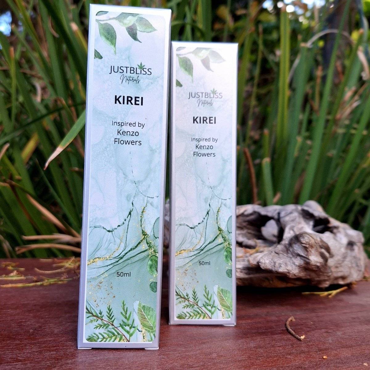 Floral Perfume Kirei 50ml bottle on wooden surface with greenery background.